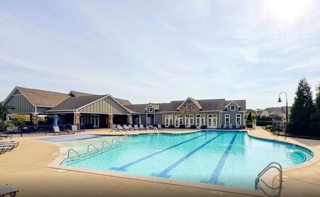 community pool featuring fence and a patio area