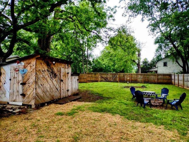 121 Swann St, Mcminnville, TN 37110 - view of yard featuring an outdoor structure, an outdoor fire pit, a fenced backyard, and a shed