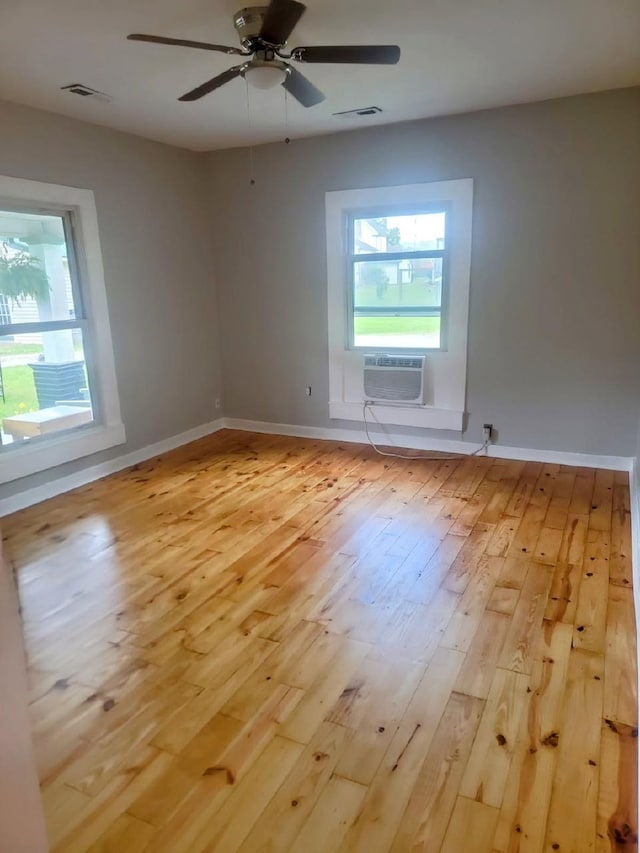121 Swann St, Mcminnville, TN 37110 - unfurnished room with light wood-type flooring, visible vents, ceiling fan, a wall unit AC, and baseboards