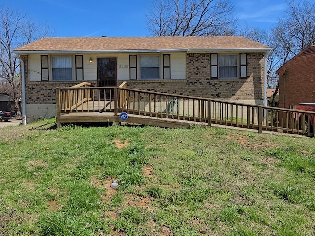 ranch-style house with brick siding, a wooden deck, and a front lawn
