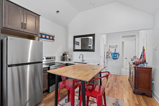 1811 Meridian St, Nashville, TN 37207 - kitchen featuring dark brown cabinets, a sink, stainless steel appliances, lofted ceiling, and light wood-type flooring