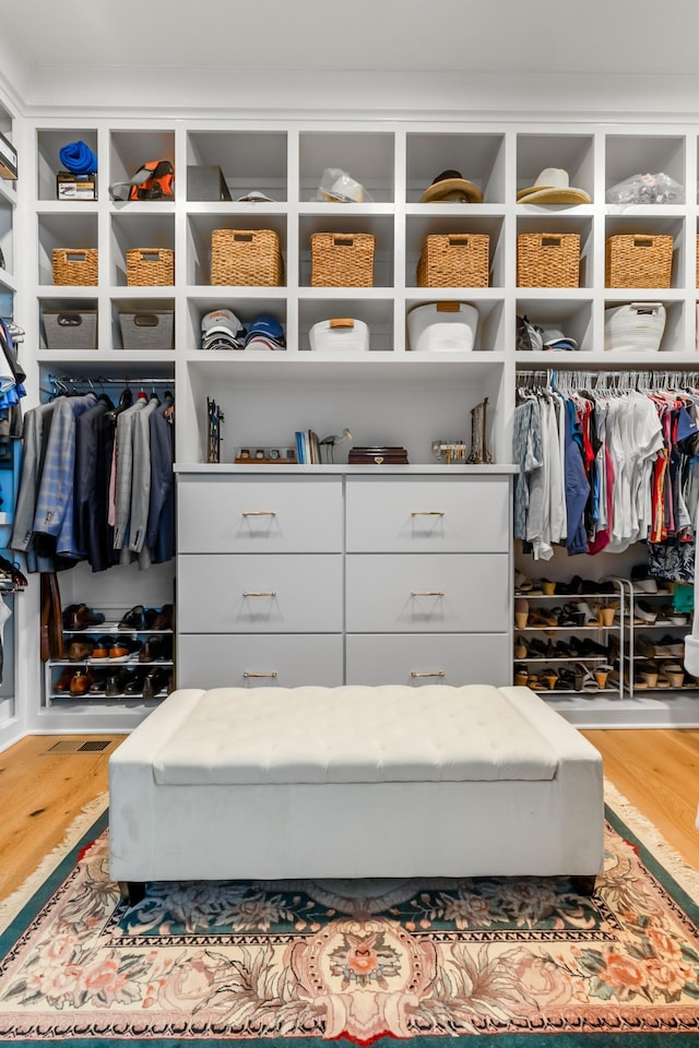 walk in closet with wood finished floors
