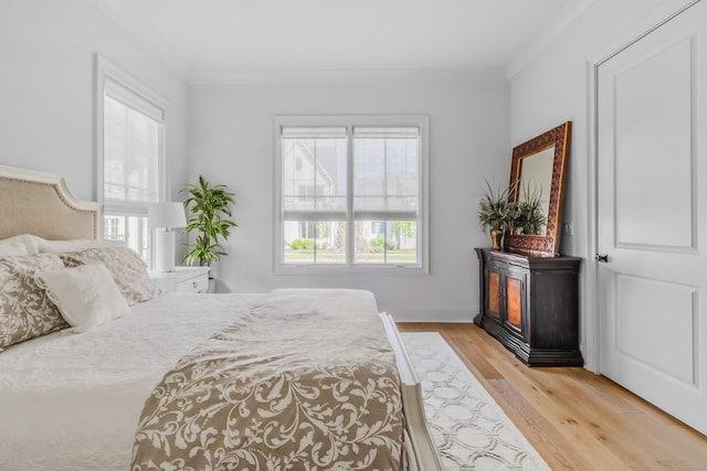 bedroom featuring light wood-type flooring and crown molding