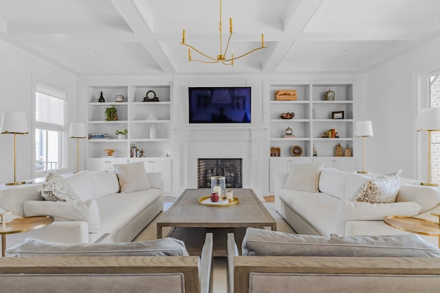 living room featuring beam ceiling, coffered ceiling, built in shelves, and a notable chandelier