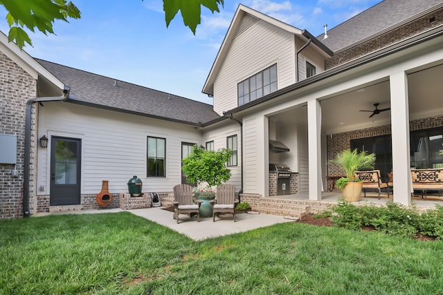 rear view of house featuring a patio, a ceiling fan, a lawn, and brick siding
