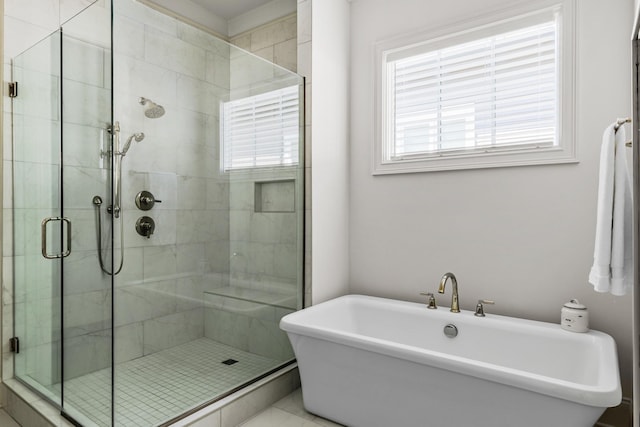 bathroom with a freestanding tub and a shower stall
