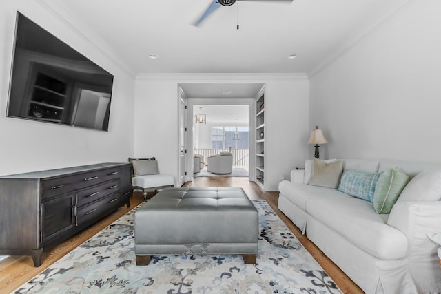 living room featuring ornamental molding, a ceiling fan, and wood finished floors