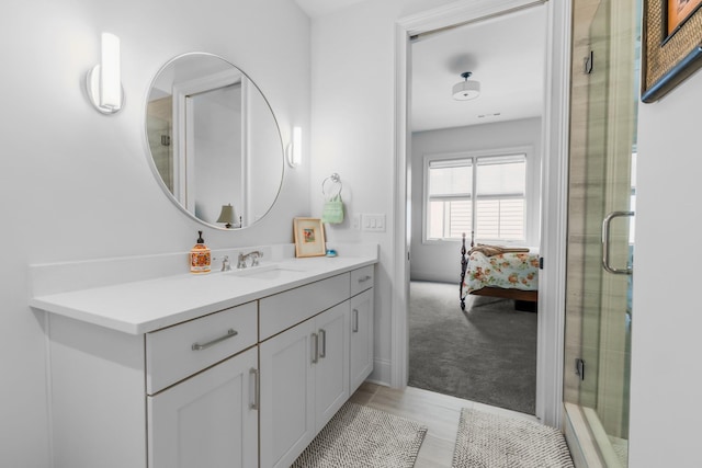 bathroom featuring vanity, a shower with shower door, and ensuite bath