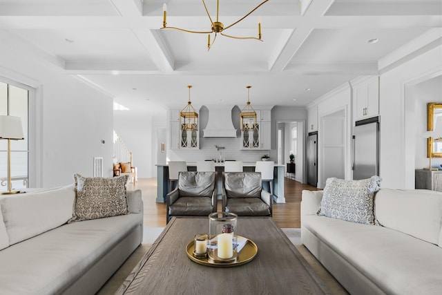 living area featuring an inviting chandelier, a wealth of natural light, wood finished floors, and coffered ceiling