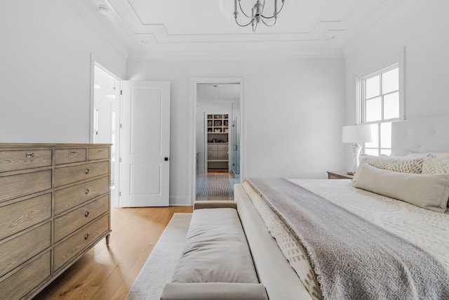 bedroom with a notable chandelier and light wood finished floors