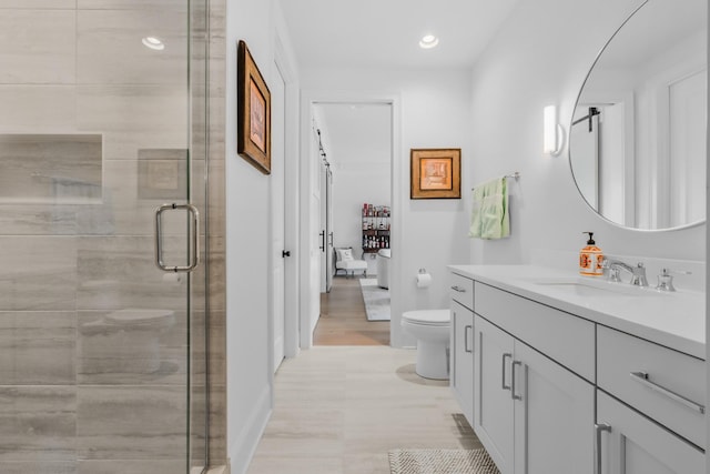 bathroom featuring recessed lighting, vanity, a stall shower, and toilet