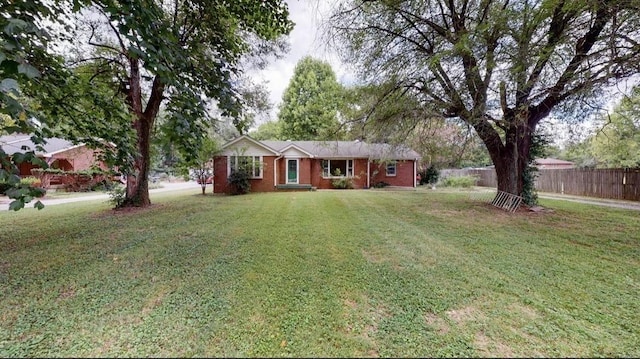 ranch-style house featuring brick siding, a front lawn, and fence