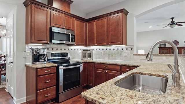 1011 Gatewick Ct, Franklin, TN 37067 - kitchen with stainless steel appliances, a sink, dark wood-style flooring, light stone counters, and recessed lighting