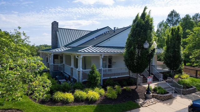 1011 Gatewick Ct, Franklin, TN 37067 - view of side of home featuring a standing seam roof, covered porch, a chimney, and metal roof