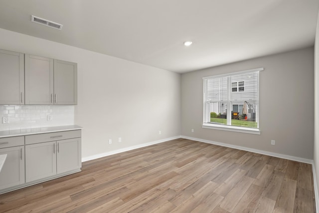 unfurnished living room featuring visible vents, recessed lighting, light wood-style floors, and baseboards
