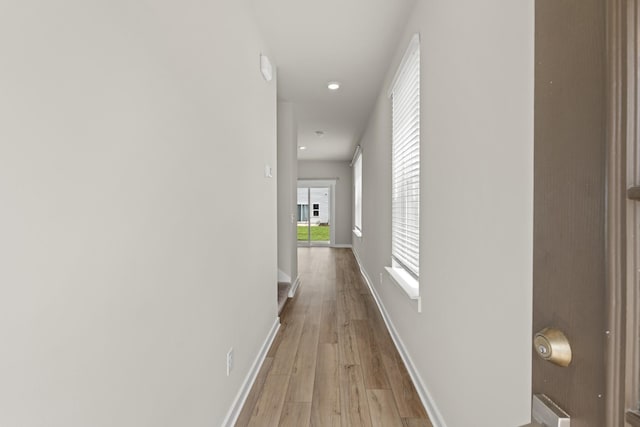hallway featuring recessed lighting, baseboards, and light wood-type flooring