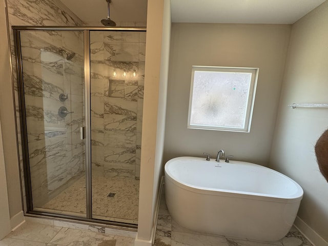 bathroom with baseboards, a freestanding bath, marble finish floor, and a stall shower
