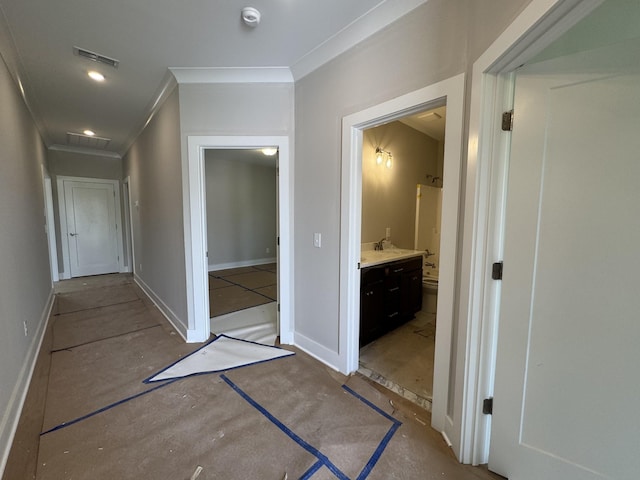 hall featuring crown molding, baseboards, and visible vents