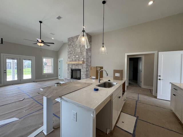 kitchen featuring a ceiling fan, visible vents, a sink, high vaulted ceiling, and white cabinetry