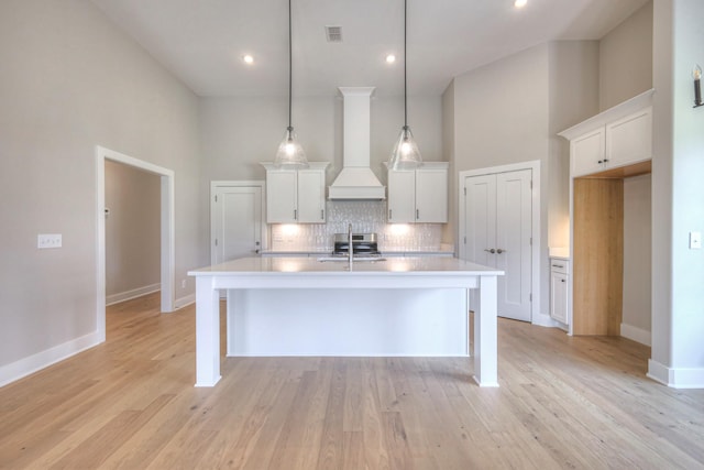 4020 Runyan Cv, Murfreesboro, TN 37127 - kitchen featuring tasteful backsplash, light countertops, white cabinetry, a center island with sink, and a towering ceiling