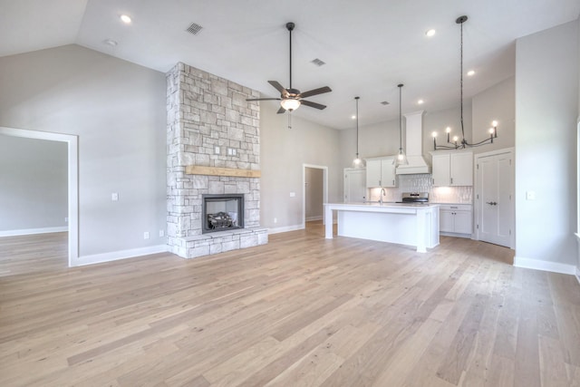 4020 Runyan Cv, Murfreesboro, TN 37127 - unfurnished living room with high vaulted ceiling, ceiling fan, a chandelier, light wood-style flooring, and a stone fireplace