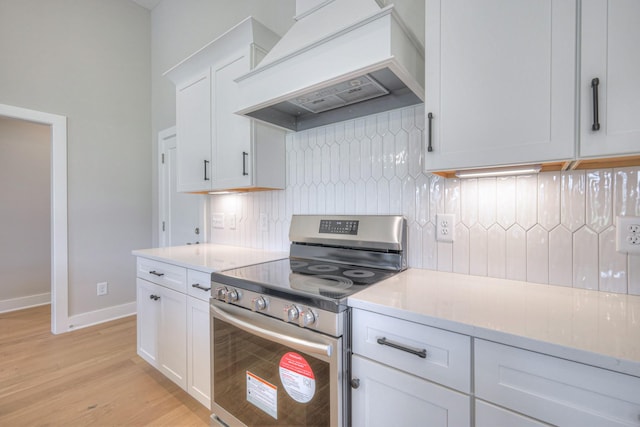 4020 Runyan Cv, Murfreesboro, TN 37127 - kitchen with stainless steel electric stove, premium range hood, decorative backsplash, light wood-style floors, and white cabinetry