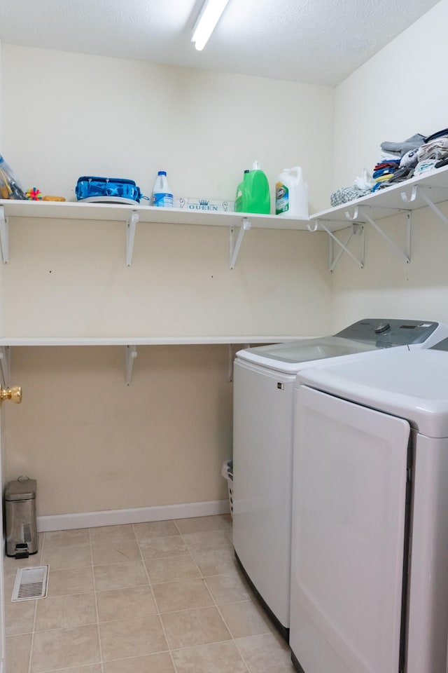 laundry room with separate washer and dryer, baseboards, laundry area, and light tile patterned flooring