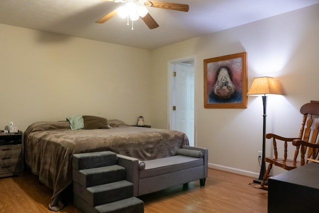bedroom featuring baseboards, a ceiling fan, and light wood-style flooring