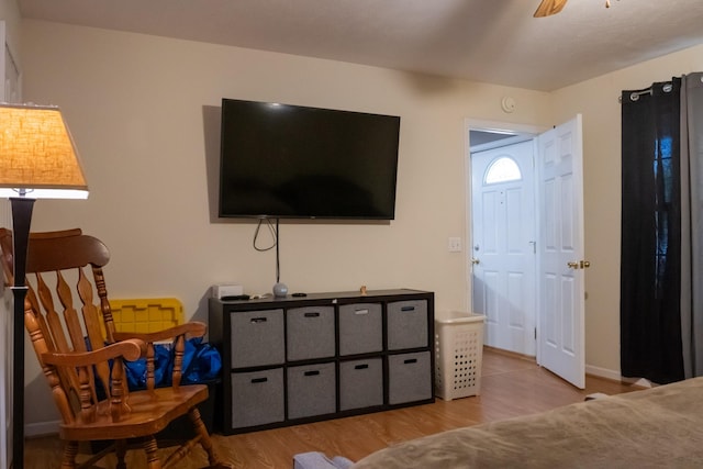 living room with baseboards, a ceiling fan, and wood finished floors