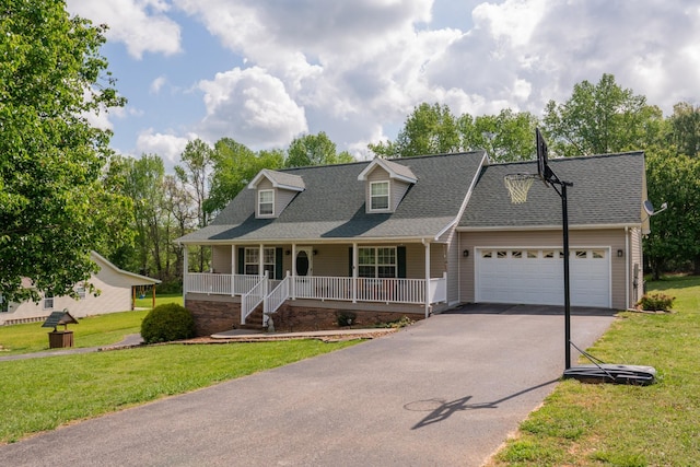 new england style home with a porch, driveway, a front yard, an attached garage, and a shingled roof