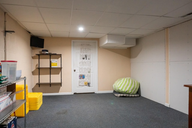 finished below grade area with visible vents, carpet, and a paneled ceiling