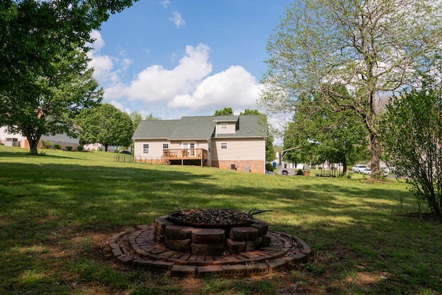 view of yard with an outdoor fire pit and a deck