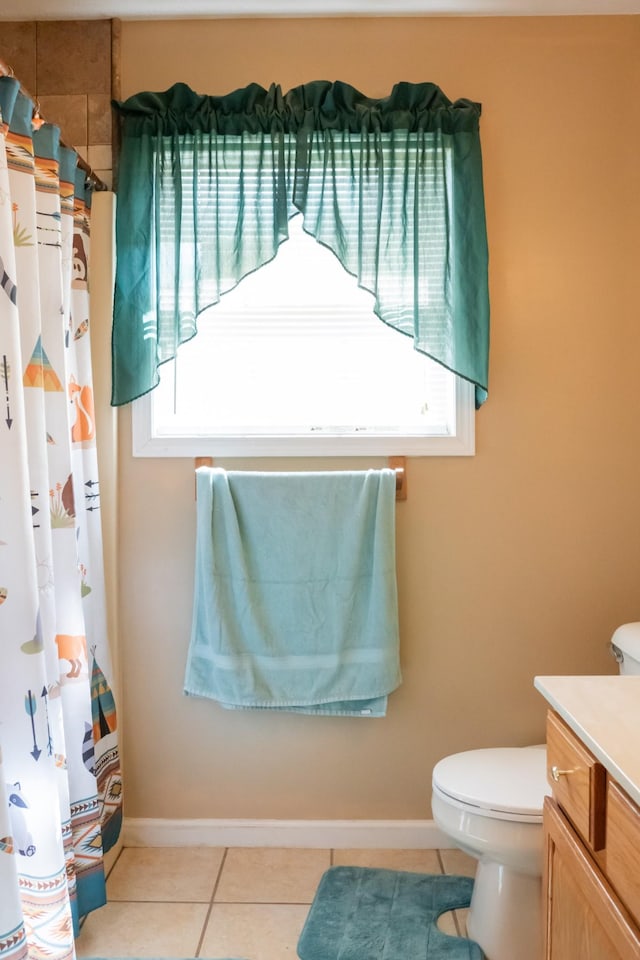 full bath featuring vanity, plenty of natural light, tile patterned floors, and toilet