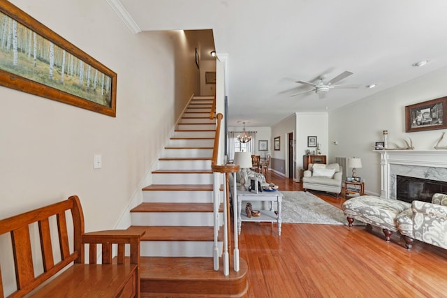 1408 Ridley Dr, Franklin, TN 37064 - stairs featuring wood finished floors, a ceiling fan, a high end fireplace, and a chandelier