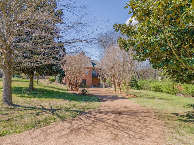 1408 Ridley Dr, Franklin, TN 37064 - obstructed view of property featuring a front yard, a chimney, asphalt driveway, and brick siding