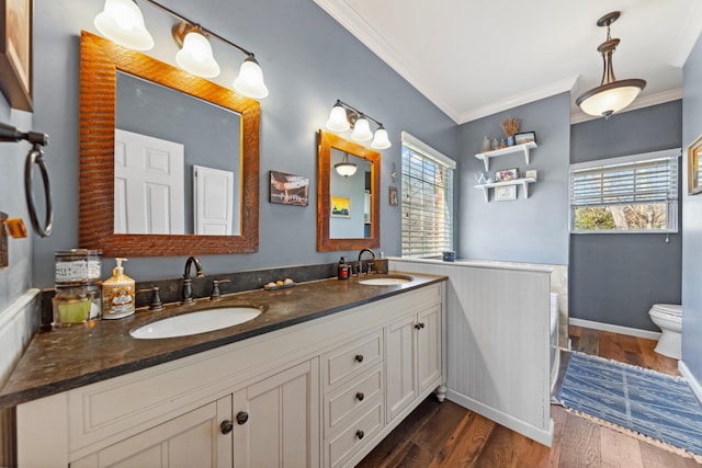 1408 Ridley Dr, Franklin, TN 37064 - bathroom with crown molding, double vanity, wood finished floors, toilet, and a wainscoted wall