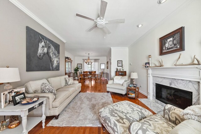 1408 Ridley Dr, Franklin, TN 37064 - living room with ornamental molding, wood finished floors, a ceiling fan, a premium fireplace, and a chandelier