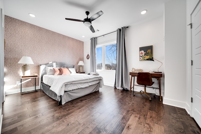 bedroom with wallpapered walls, baseboards, an accent wall, and hardwood / wood-style floors