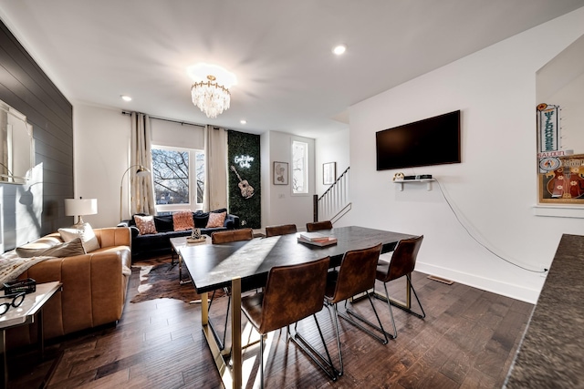 dining space featuring recessed lighting, dark wood finished floors, stairs, and a chandelier