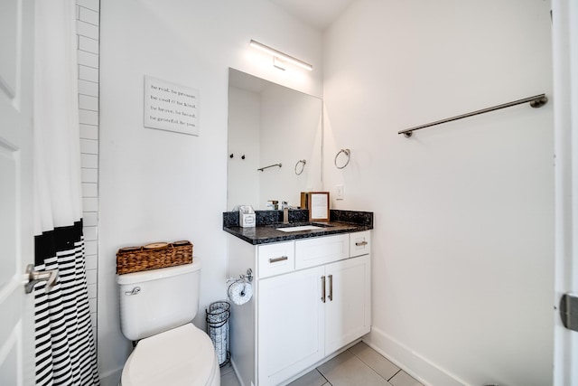 bathroom featuring toilet, tile patterned floors, baseboards, and vanity