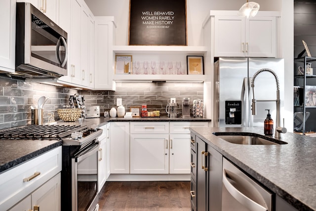 kitchen featuring open shelves, white cabinetry, a sink, dark wood finished floors, and stainless steel appliances