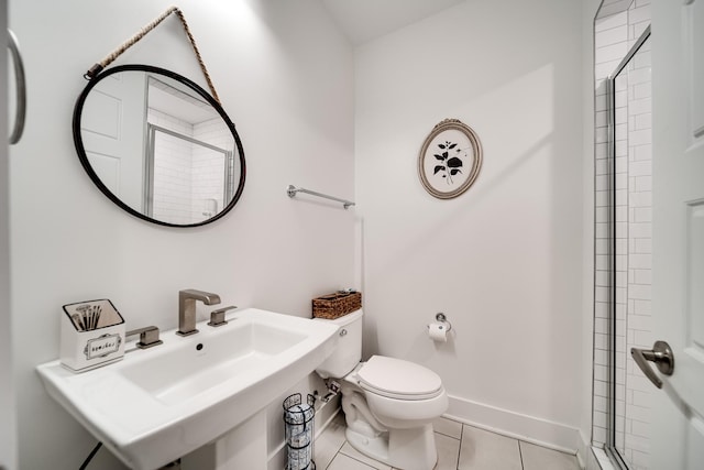 full bathroom with toilet, baseboards, walk in shower, tile patterned floors, and a sink