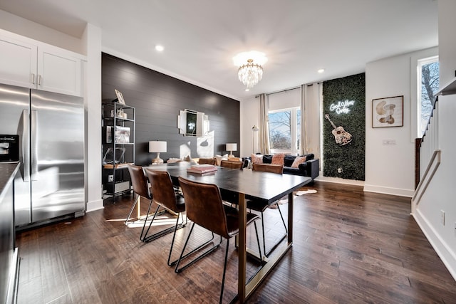 dining room featuring baseboards, a notable chandelier, a wealth of natural light, and stairway