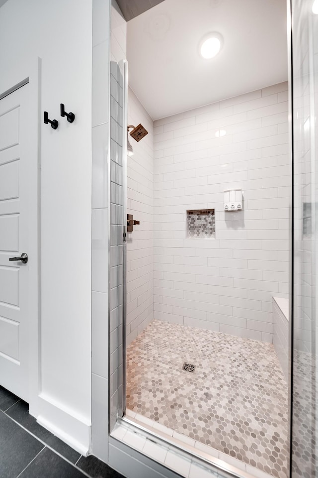 bathroom with tile patterned floors and a shower stall