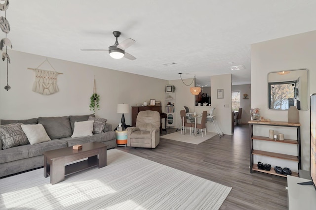 living room featuring ceiling fan, visible vents, and wood finished floors