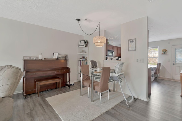 dining space with light wood-style floors, baseboards, and visible vents