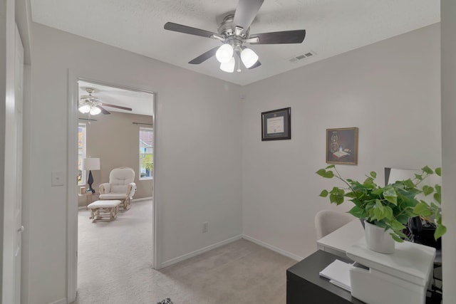 office with visible vents, baseboards, light colored carpet, a textured ceiling, and a ceiling fan
