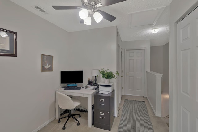 office space with visible vents, a ceiling fan, a textured ceiling, and baseboards