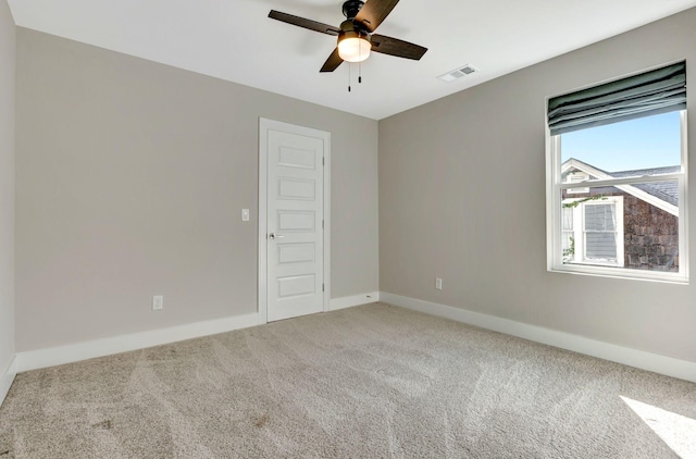 empty room featuring baseboards, a ceiling fan, carpet flooring, and visible vents