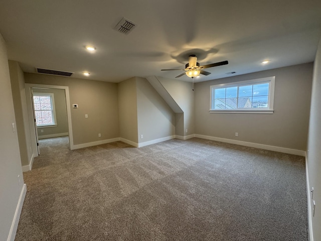 additional living space with visible vents, recessed lighting, and carpet